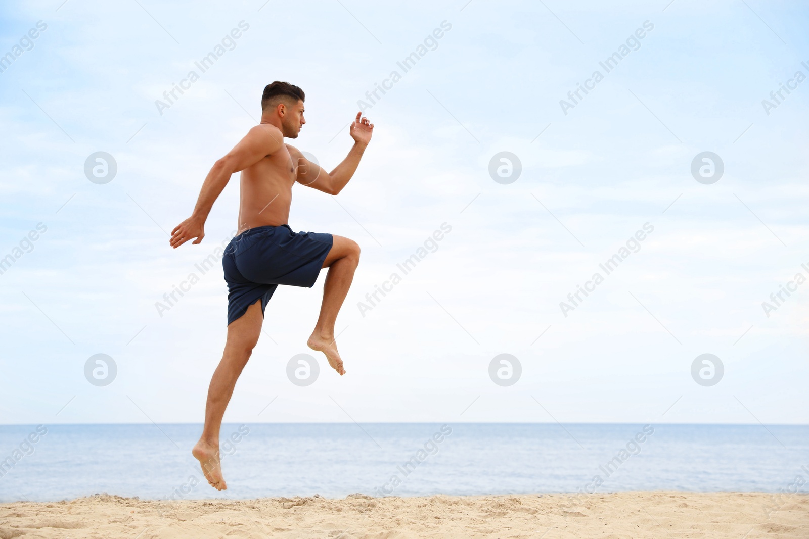 Photo of Muscular man doing exercise on beach, space for text. Body training