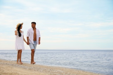 Photo of Lovely couple walking on beach. Space for text