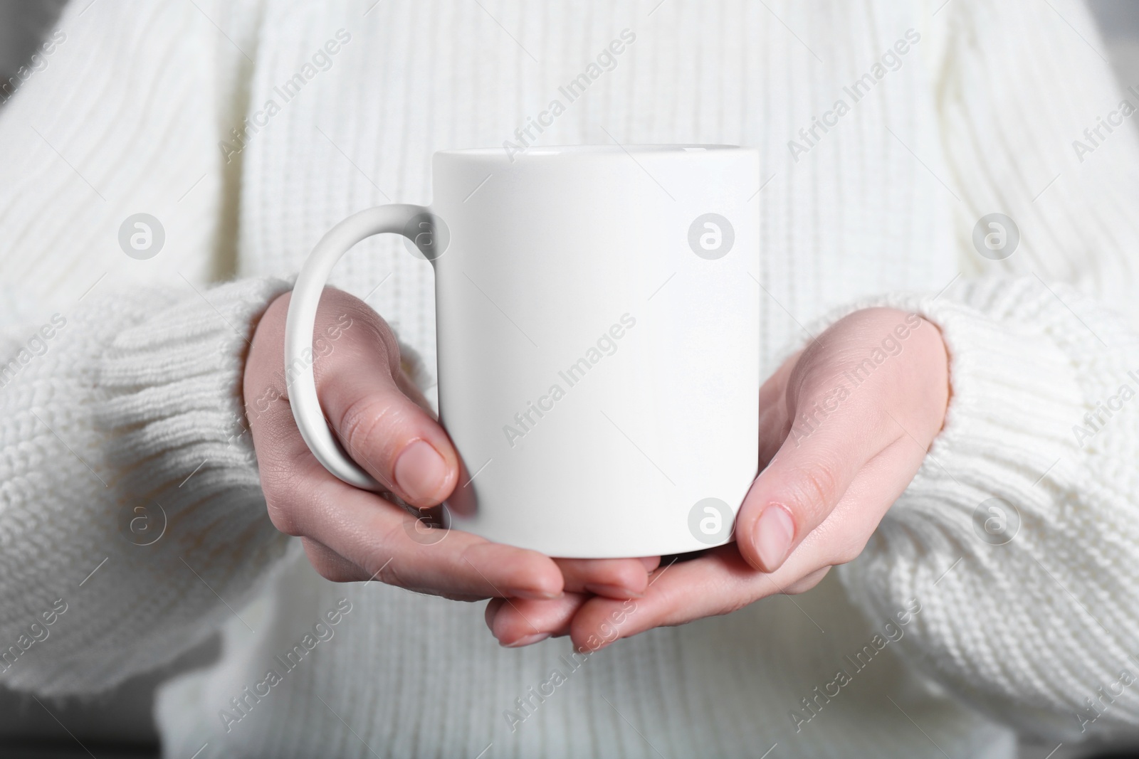 Photo of Woman holding blank white ceramic mug, closeup. Mockup for design