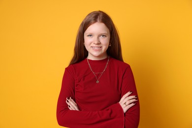 Teenage girl wearing stylish jewellery on yellow background