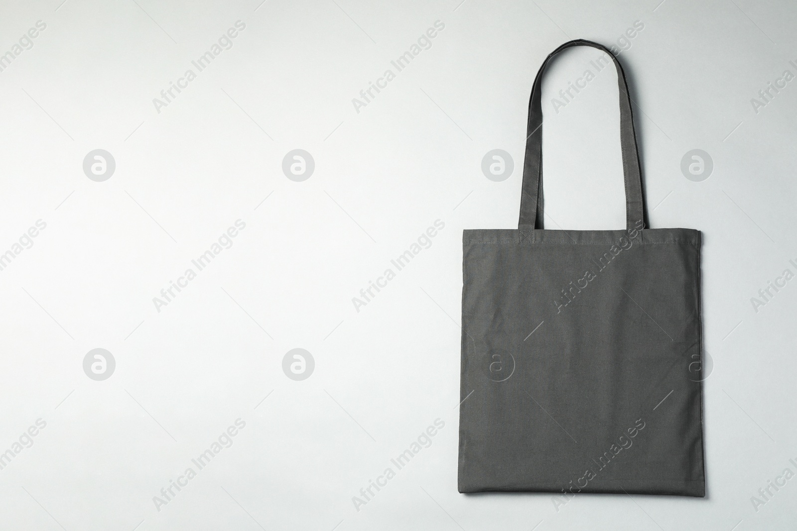 Photo of One shopping bag and space for text on grey background, top view. Mockup for design