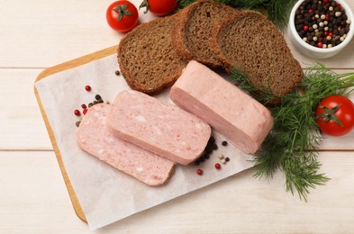 Pieces of tasty canned meat, tomatoes, peppercorns, dill and bread on light wooden table, flat lay