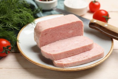 Pieces of tasty canned meat, dill and tomatoes on light wooden table, closeup