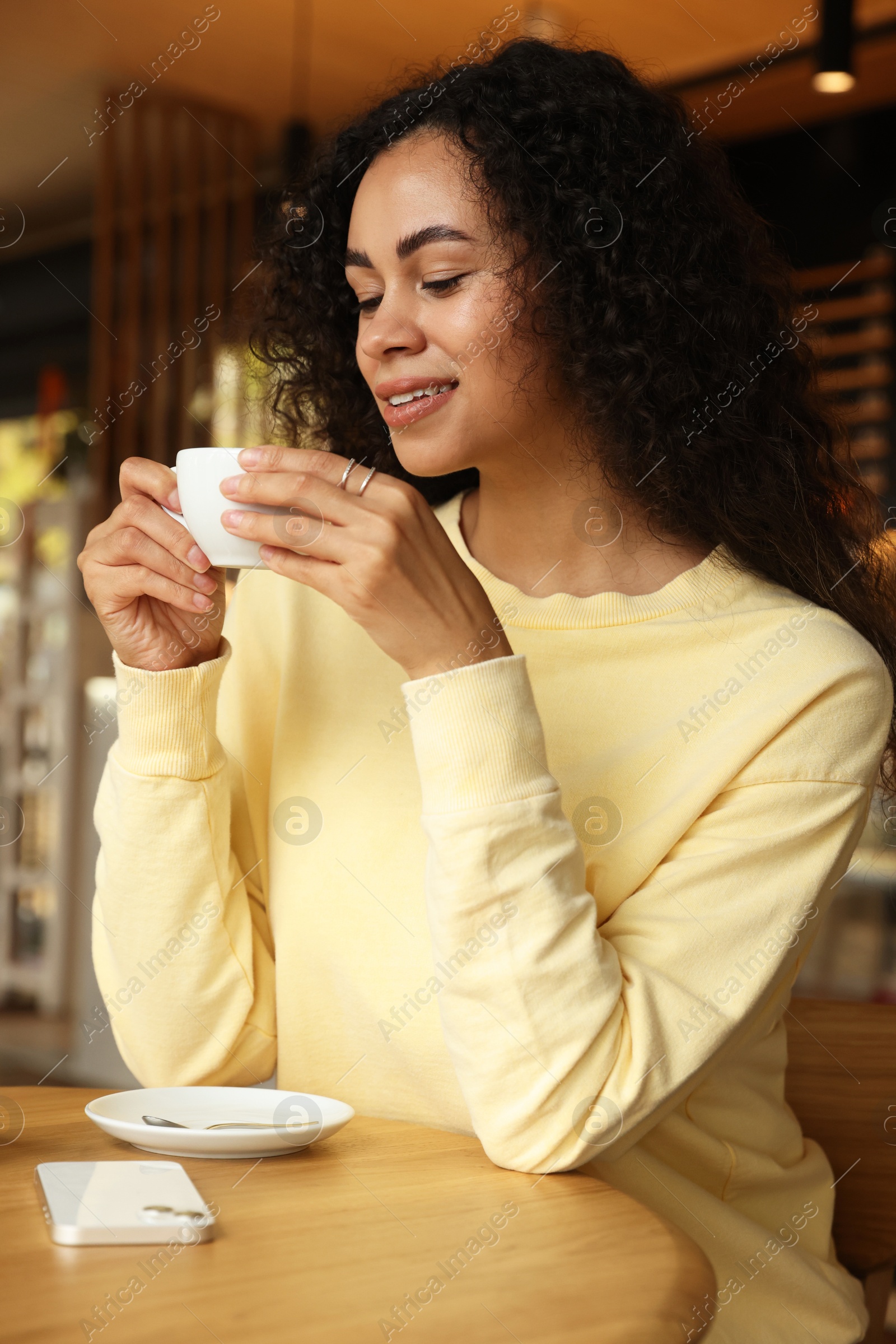 Photo of Woman enjoying her aromatic coffee at table in cafe