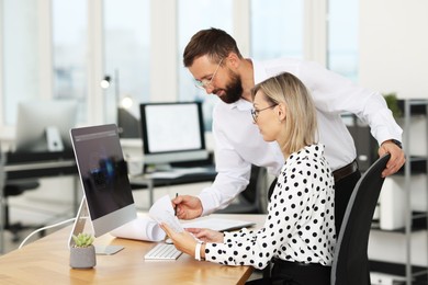 Technicians making digital engineering drawing on computer at desk in office