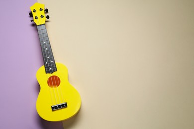 Photo of One ukulele on color background, top view. Space for text