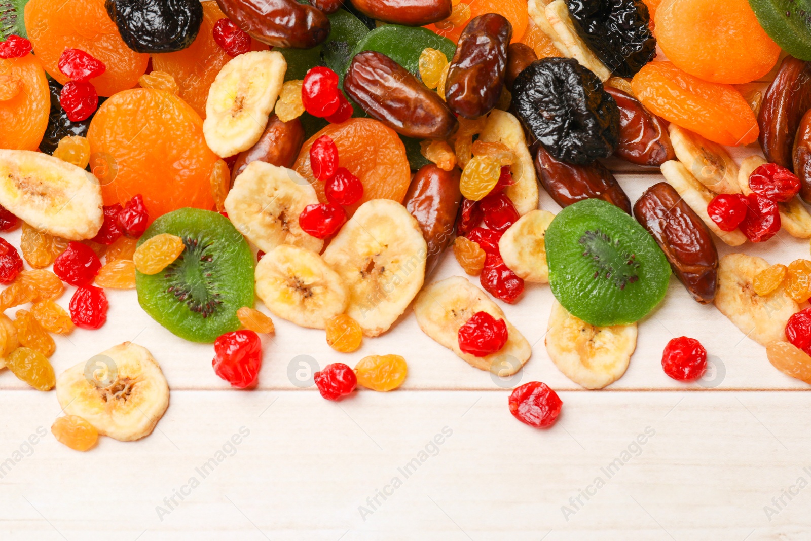 Photo of Mix of different dried fruits on wooden table, top view