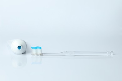 Photo of Toothbrush with toothpaste and tube on white background
