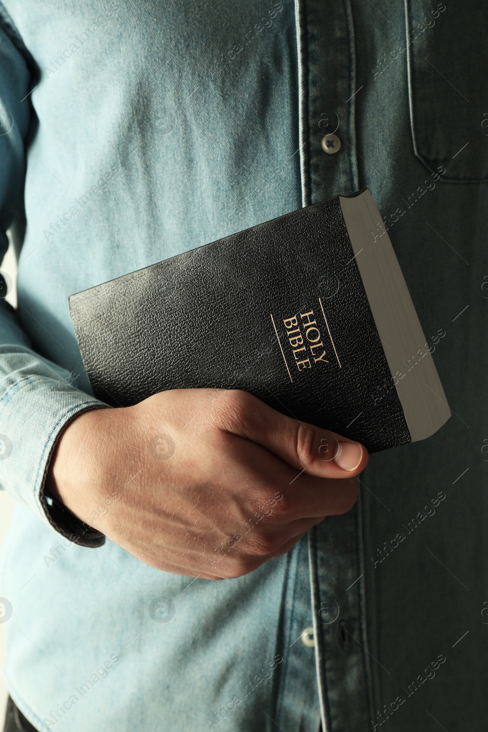 Photo of Man with hardcover Holy Bible, closeup view