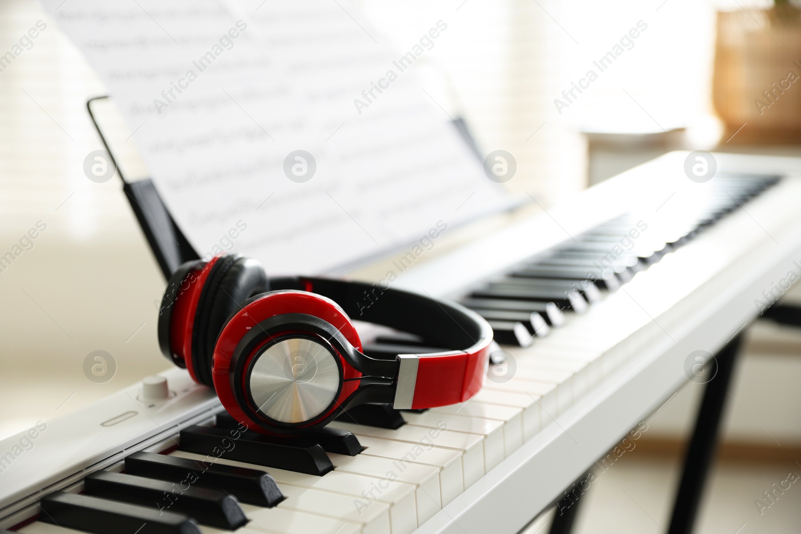 Photo of Synthesizer with music sheets and headphones indoors, closeup