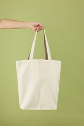 Photo of Woman with blank shopper bag on color background, closeup. Mockup for design