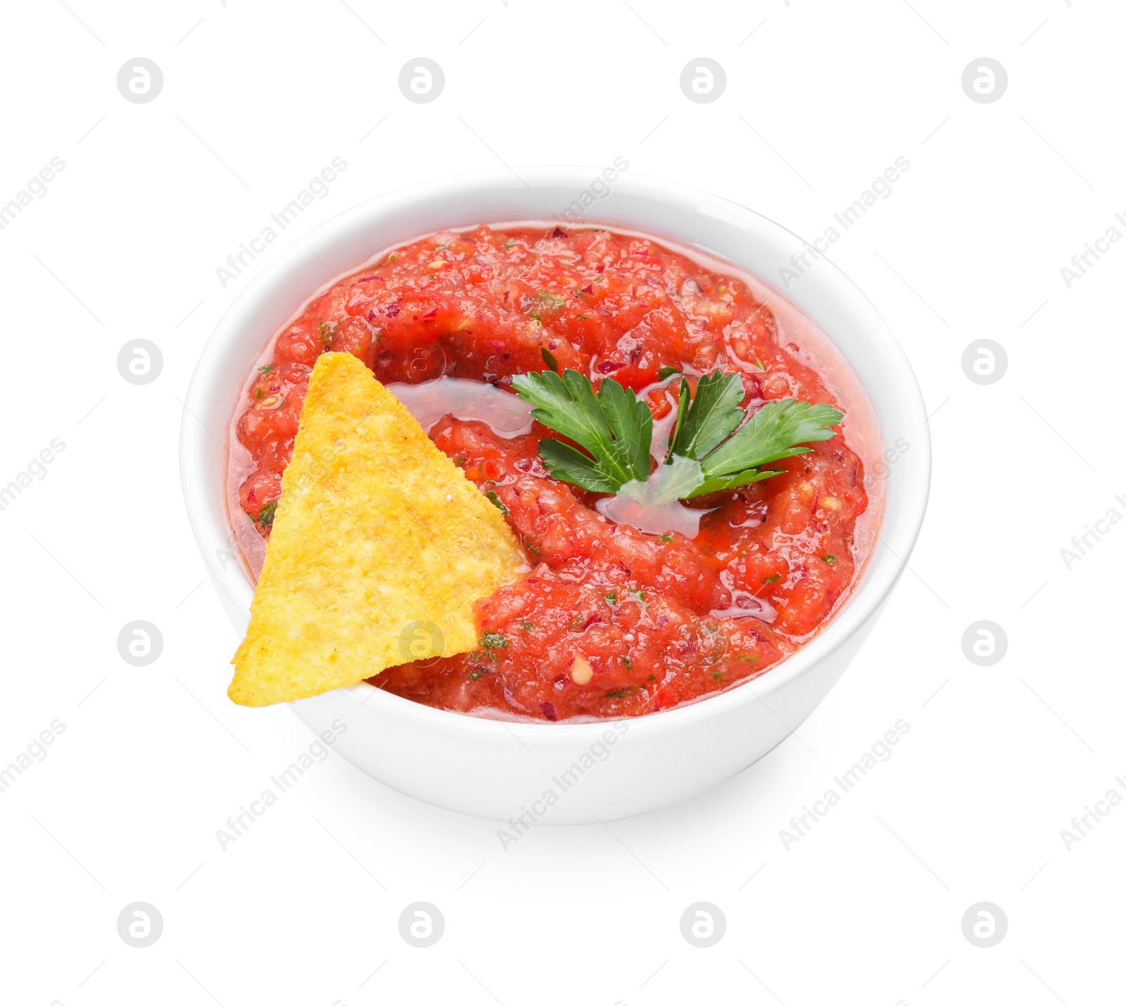 Photo of Delicious spicy salsa sauce with nacho chip in bowl isolated on white