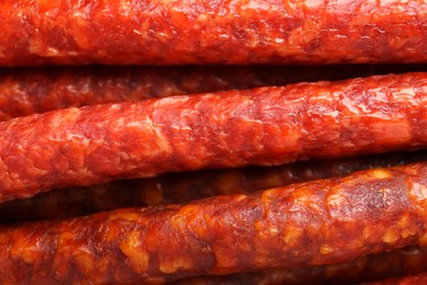 Photo of Many tasty smoked sausages as background, top view