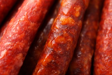 Photo of Different tasty smoked sausages as background, closeup