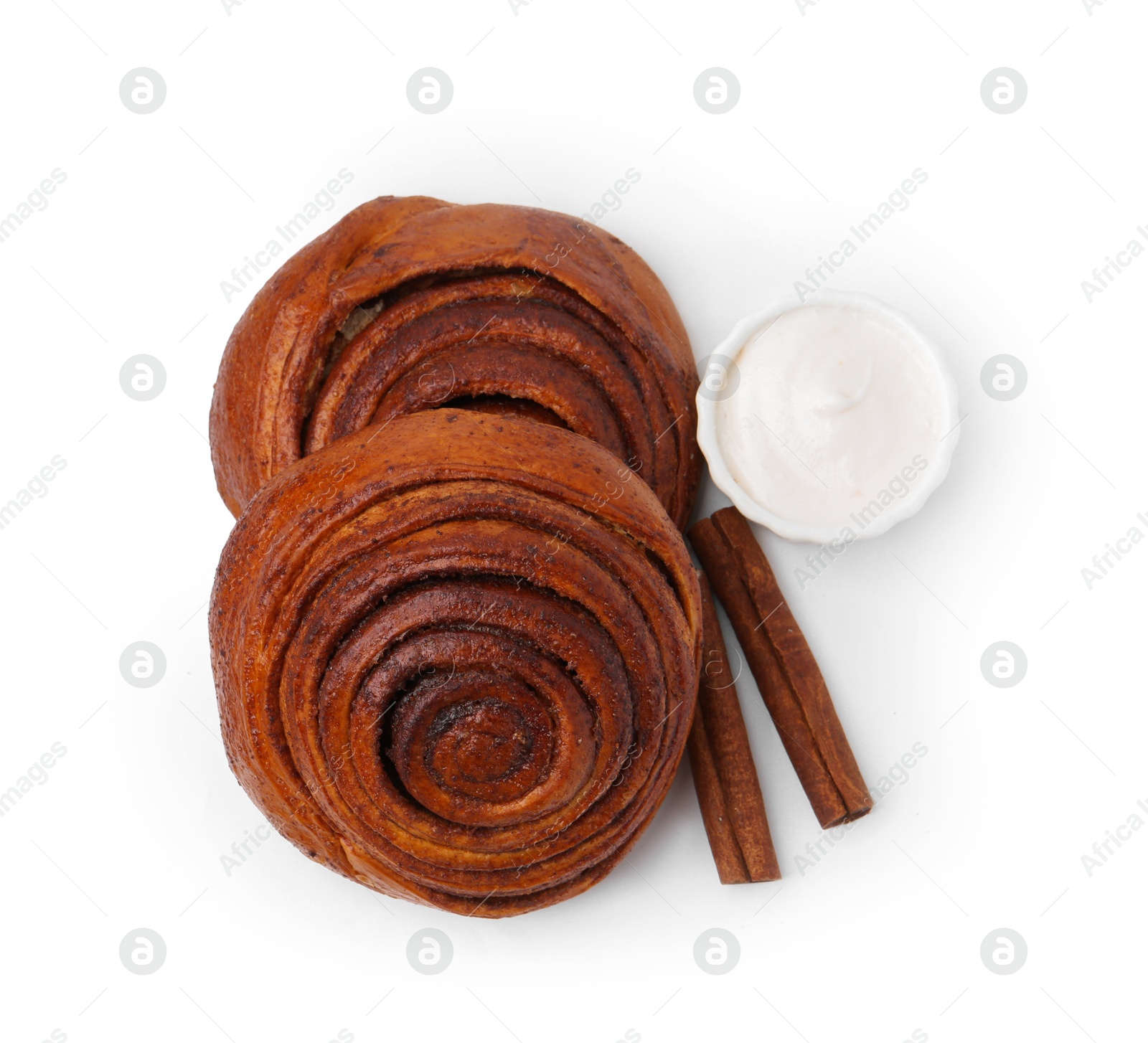 Photo of Tasty cinnamon rolls with cream and sticks isolated on white, top view