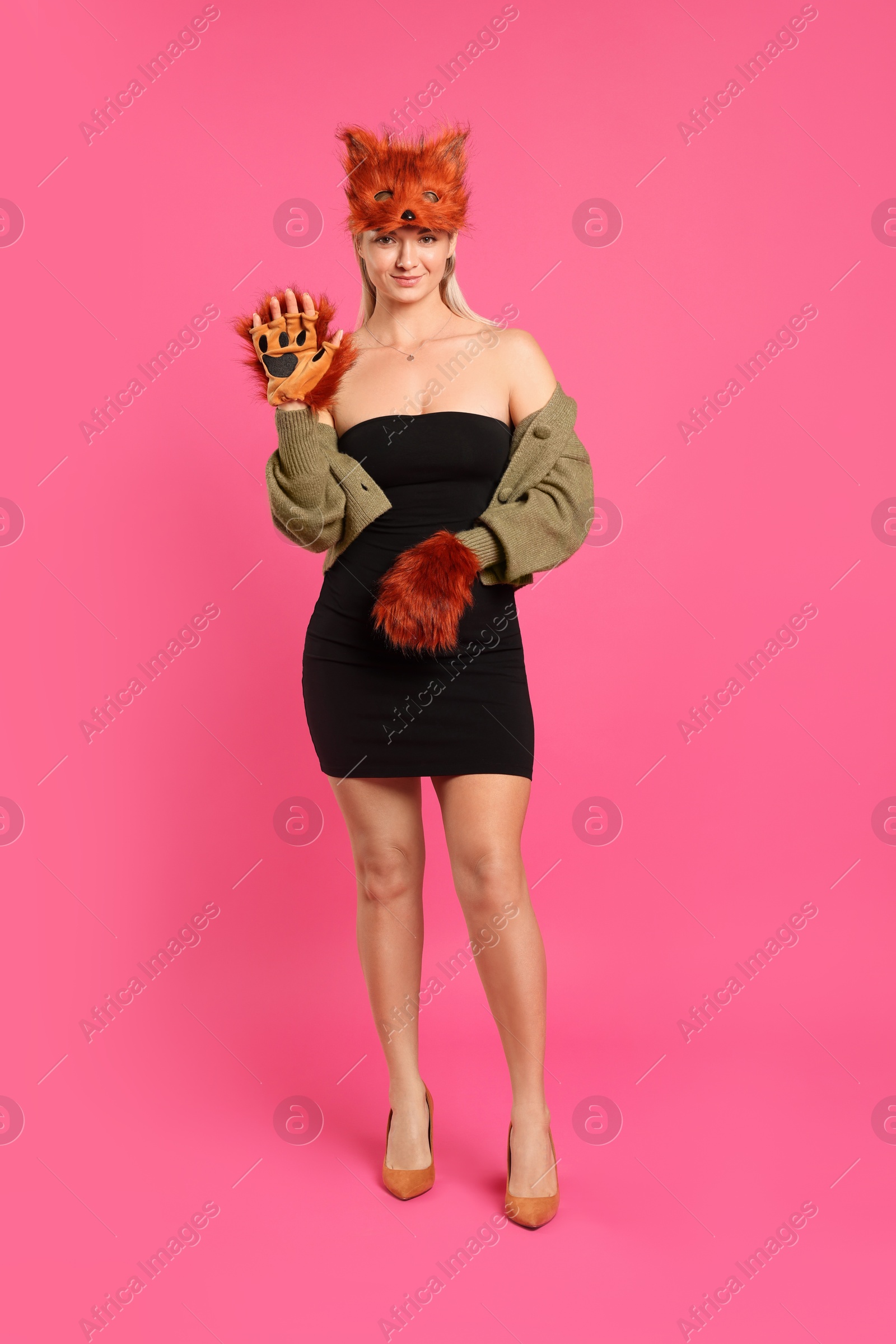 Photo of Quadrobics. Woman wearing fox mask and gloves on pink background