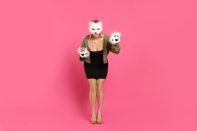 Quadrobics. Woman wearing cat mask and gloves on pink background