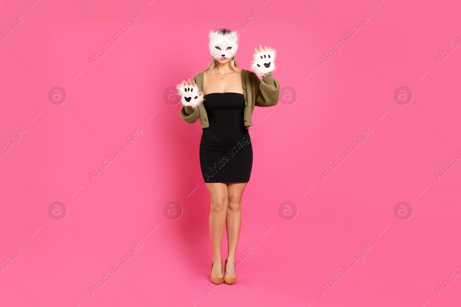 Photo of Quadrobics. Woman wearing cat mask and gloves on pink background