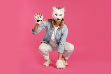 Quadrobics. Woman wearing cat mask and gloves on pink background