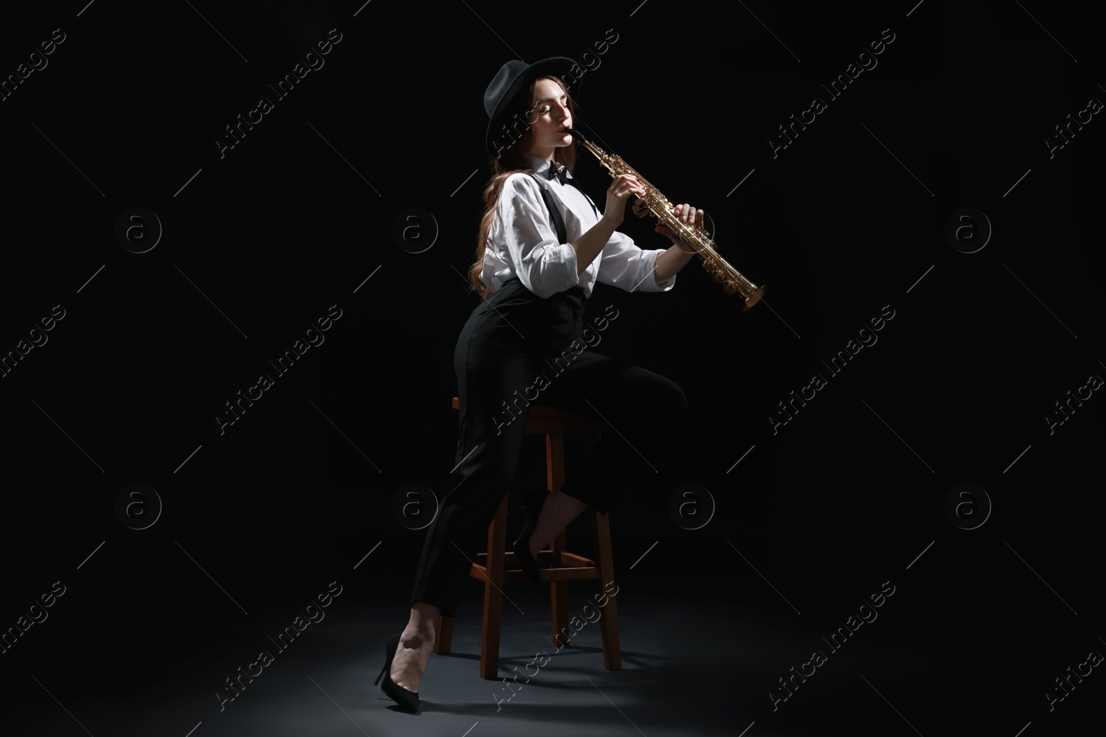 Photo of Musician playing soprano saxophone on dark background