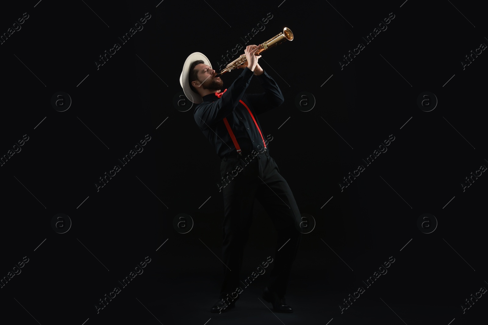 Photo of Professional musician playing soprano saxophone on black background