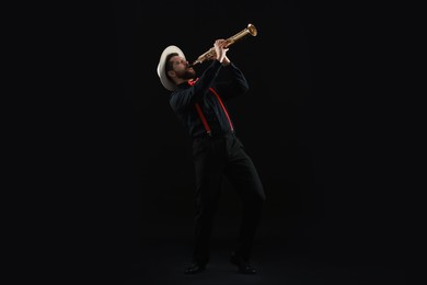 Photo of Professional musician playing soprano saxophone on black background