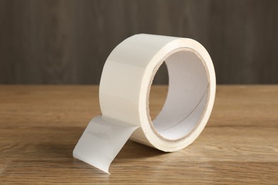 Roll of masking tape on wooden table, closeup