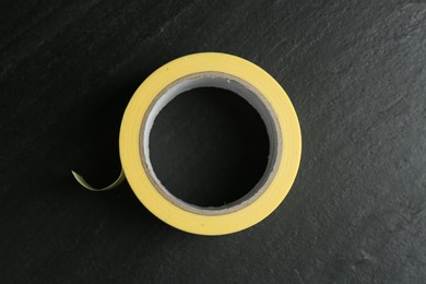 Roll of masking tape on black table, top view