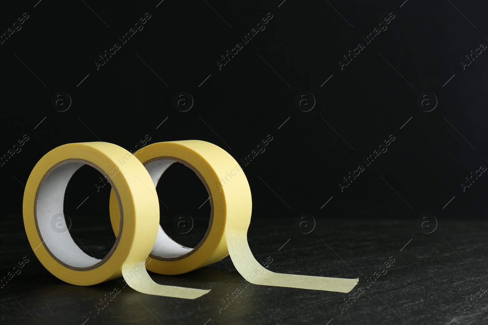 Photo of Rolls of masking tape on black table, space for text