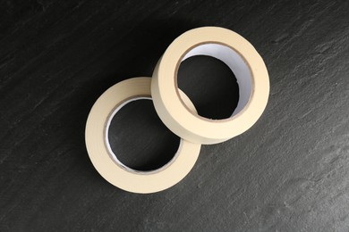 Photo of Rolls of masking tape on black table, top view