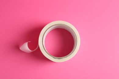 One masking tape on pink background, top view