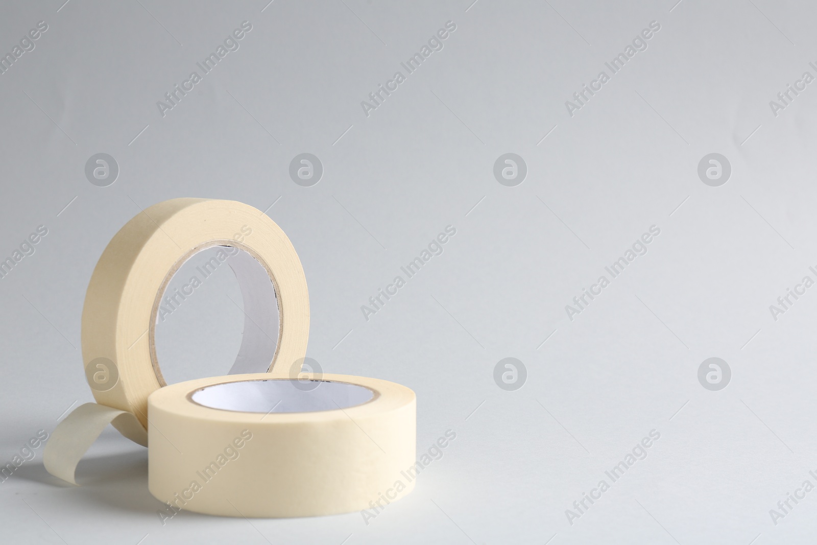 Photo of Two masking tapes on grey background, closeup. Space for text