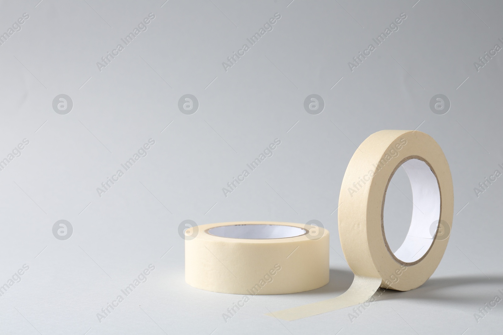 Photo of Two masking tapes on grey background, closeup. Space for text