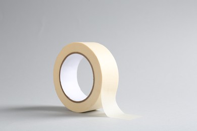 Photo of One masking tape on grey background, closeup