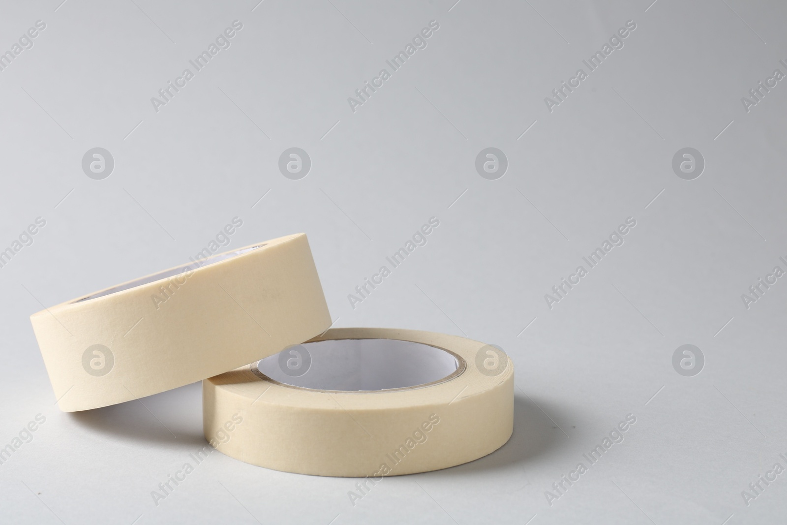 Photo of Two masking tapes on grey background, closeup. Space for text