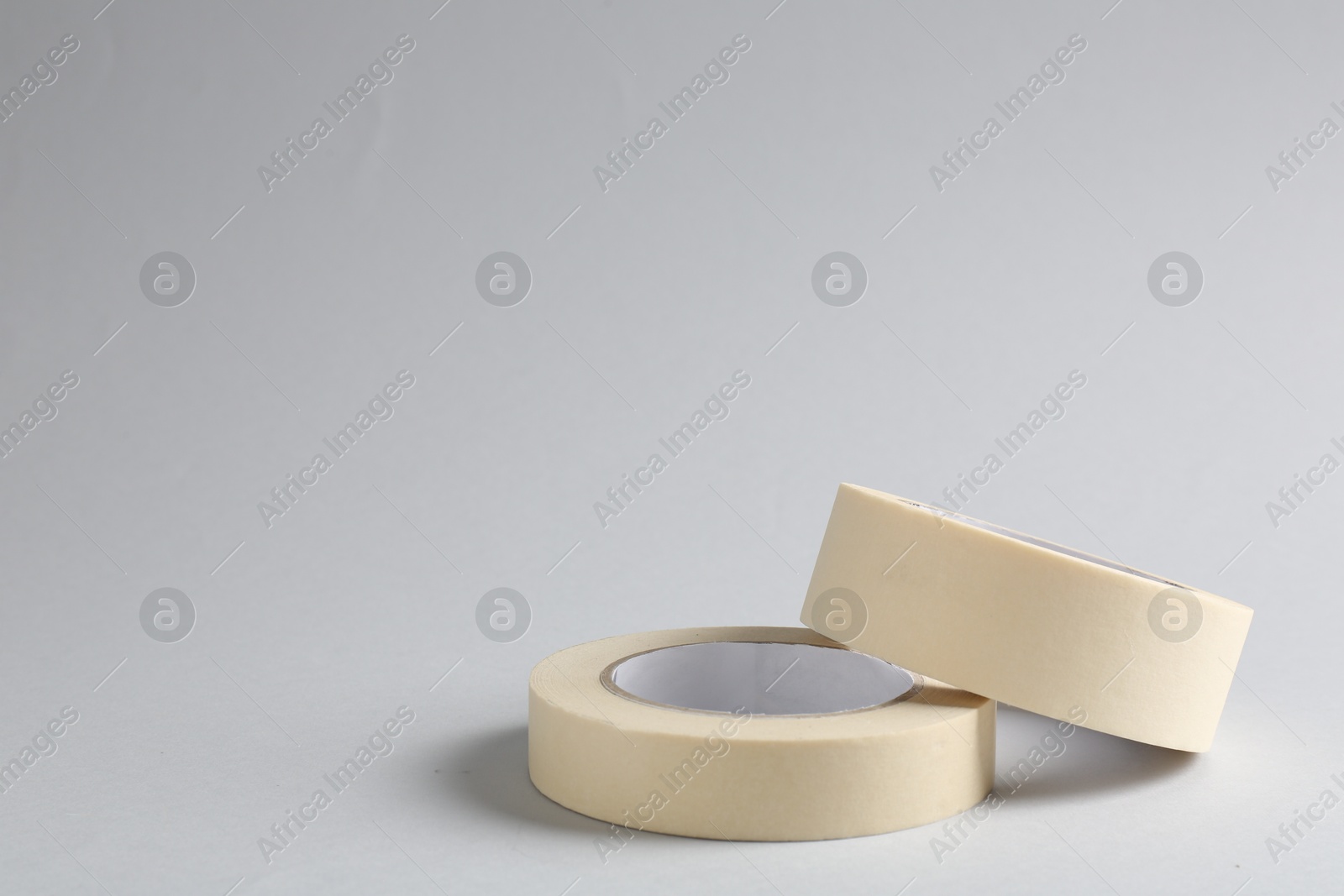 Photo of Two masking tapes on grey background, closeup. Space for text