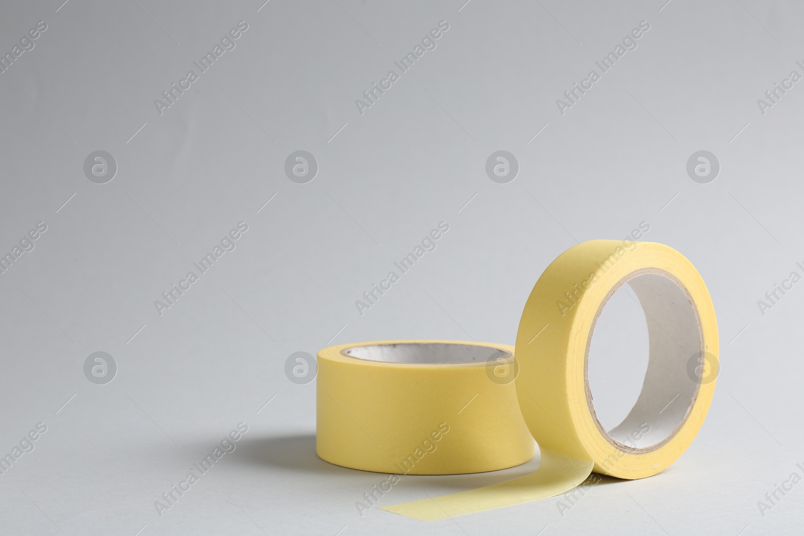 Photo of Two masking tapes on grey background, closeup. Space for text