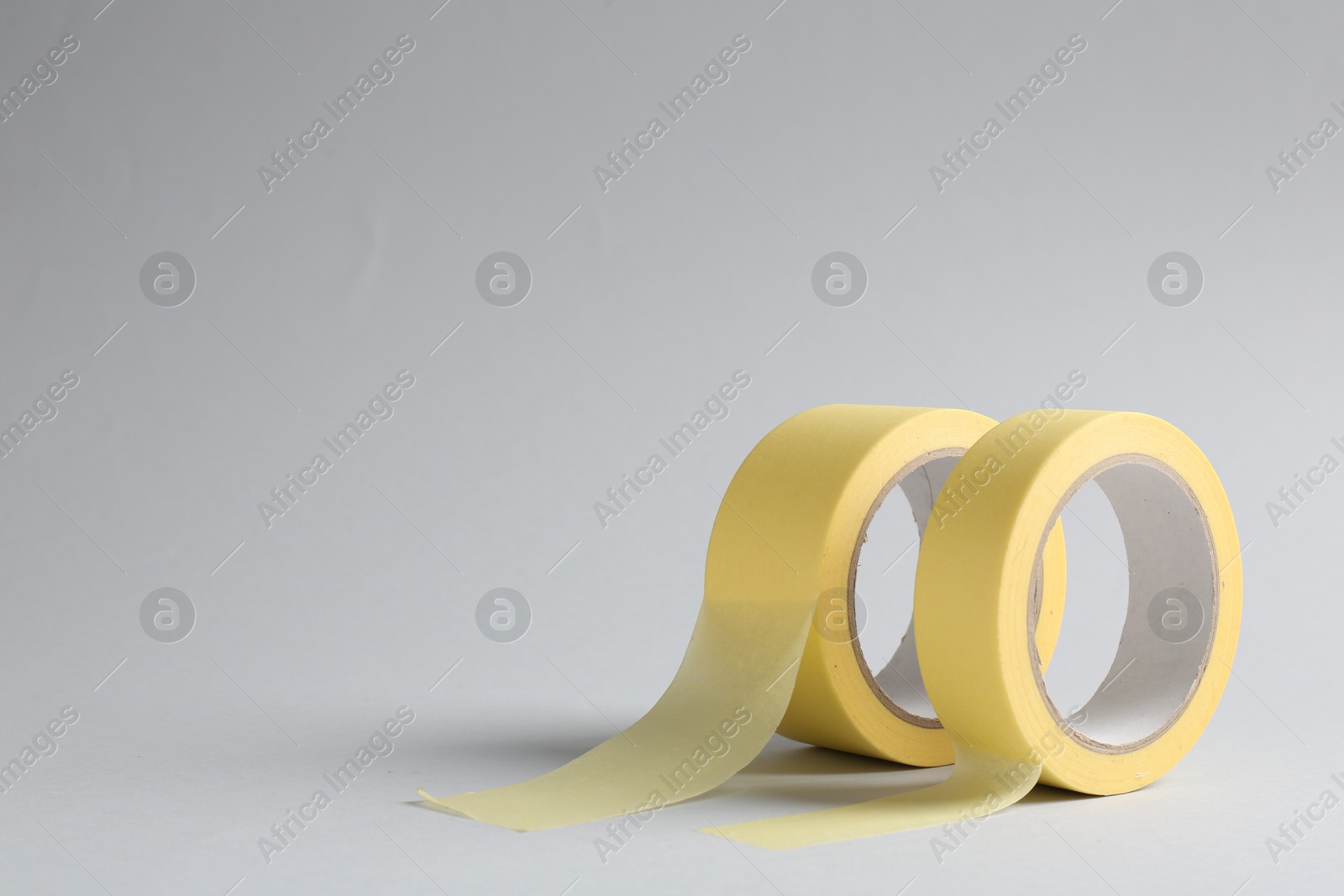 Photo of Two masking tapes on grey background, closeup. Space for text