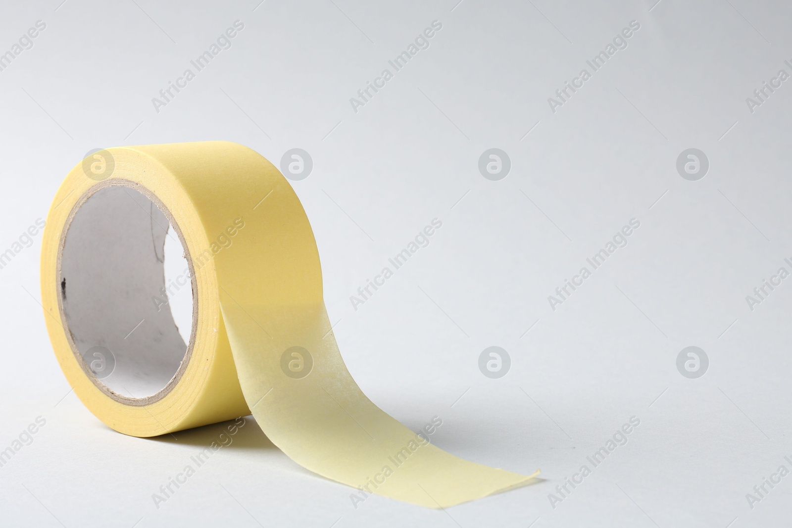 Photo of One masking tape on grey background, closeup. Space for text