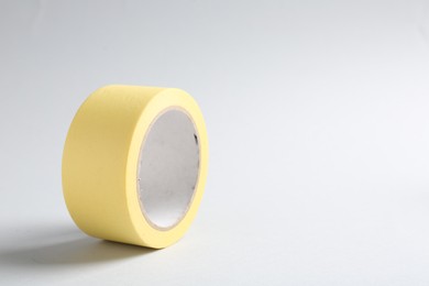 Photo of One masking tape on grey background, closeup. Space for text