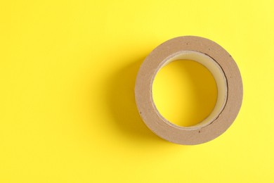 One masking tape on yellow background, top view. Space for text