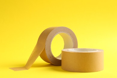 Two masking tapes on yellow background, closeup