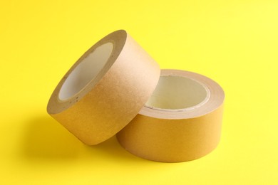 Photo of Two masking tapes on yellow background, closeup