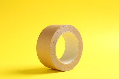 One masking tape on yellow background, closeup