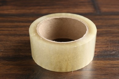 One adhesive tape on wooden table, closeup