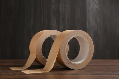 Photo of Two masking tapes on wooden table, closeup