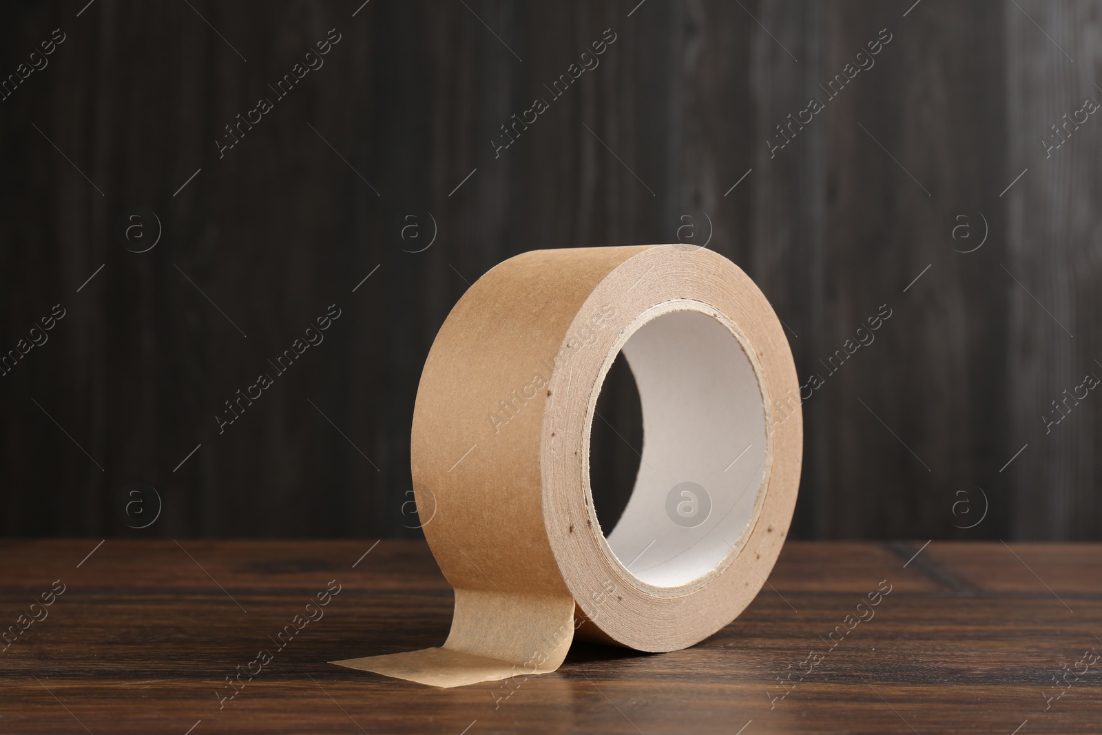 Photo of One masking tape on wooden table, closeup