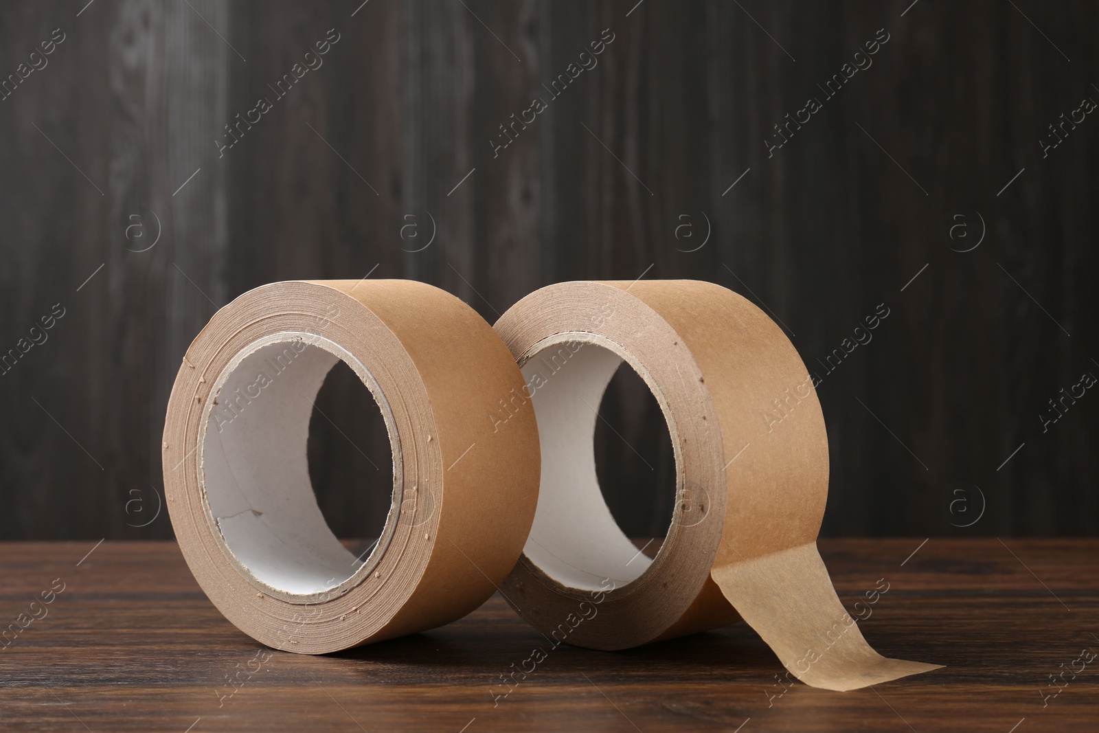 Photo of Two masking tapes on wooden table, closeup