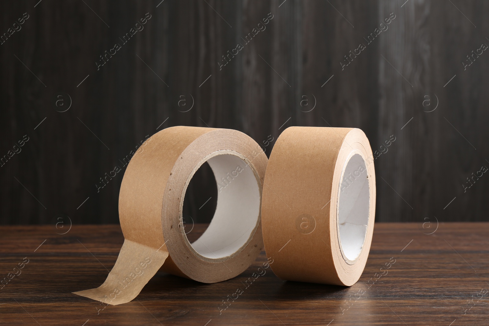 Photo of Two masking tapes on wooden table, closeup