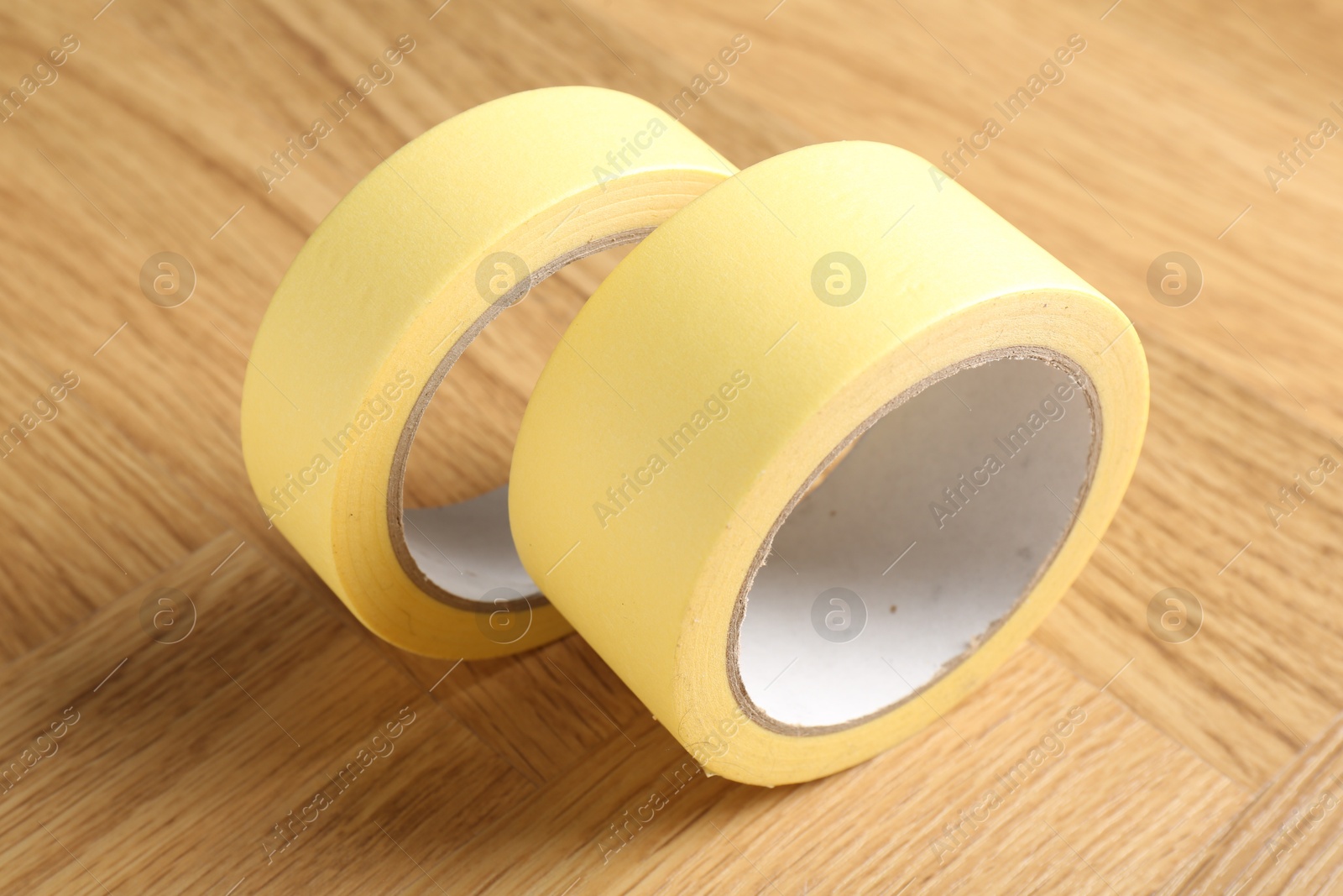 Photo of Two masking tapes on wooden table, closeup